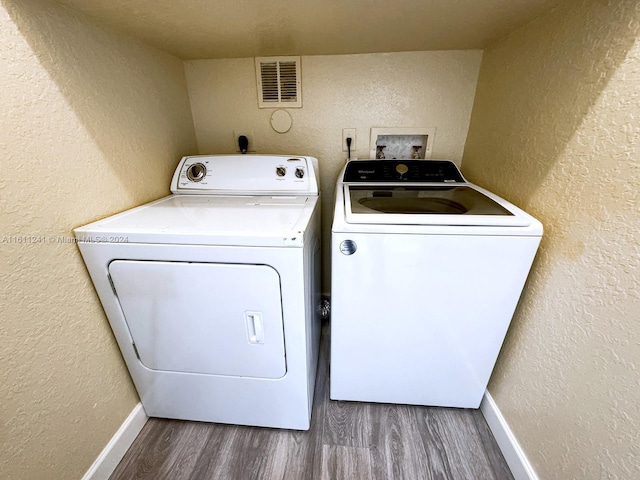 washroom with hardwood / wood-style floors and washer and clothes dryer