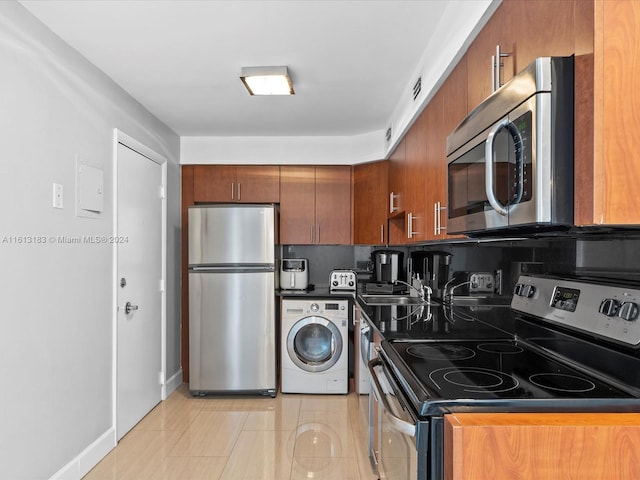 kitchen featuring brown cabinetry, light tile patterned flooring, washer / dryer, stainless steel appliances, and visible vents