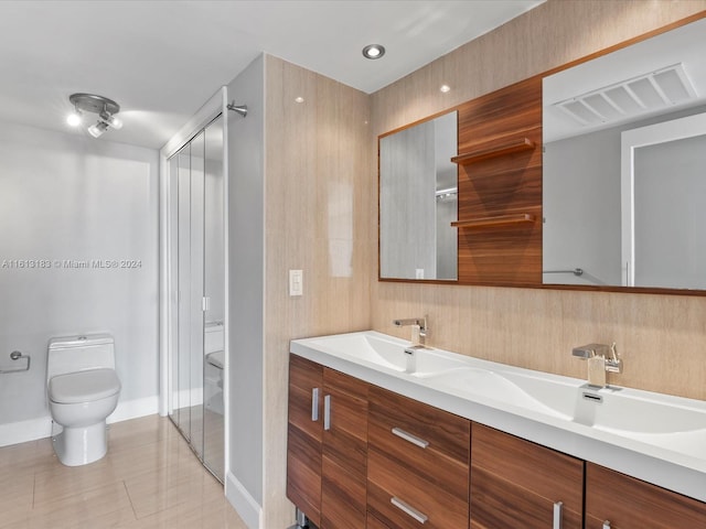 bathroom featuring tile floors, double sink, oversized vanity, and toilet