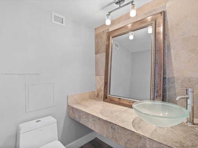 bathroom with visible vents, a sink, and toilet