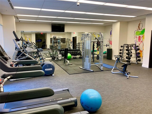 exercise room featuring carpet and a drop ceiling