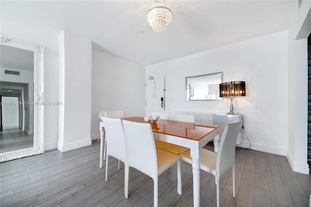 dining space featuring hardwood / wood-style flooring and a chandelier