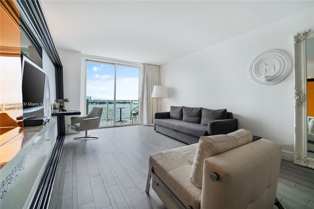 living room featuring a water view, expansive windows, and hardwood / wood-style floors