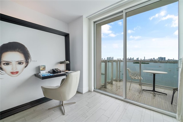 office area featuring light hardwood / wood-style floors and a water view