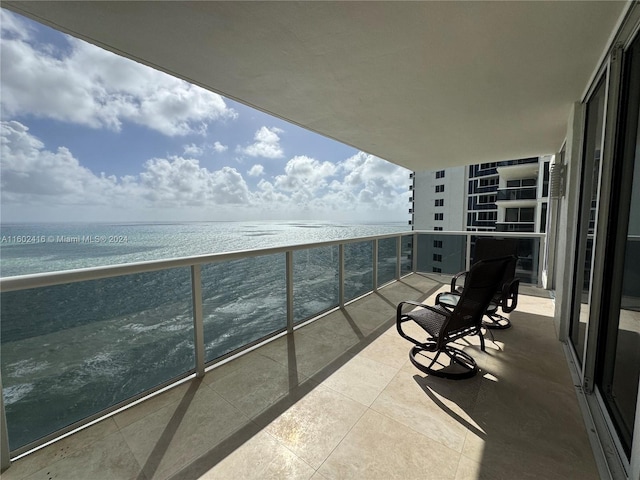 balcony with a water view and a view of the beach