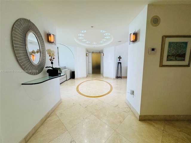 corridor with light tile patterned floors and baseboards
