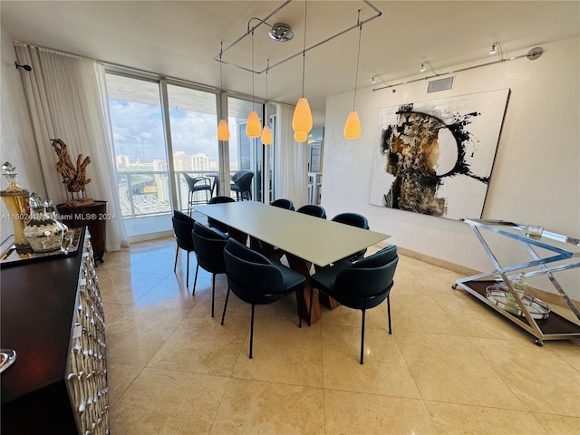 dining room featuring visible vents, light tile patterned floors, and a wall of windows