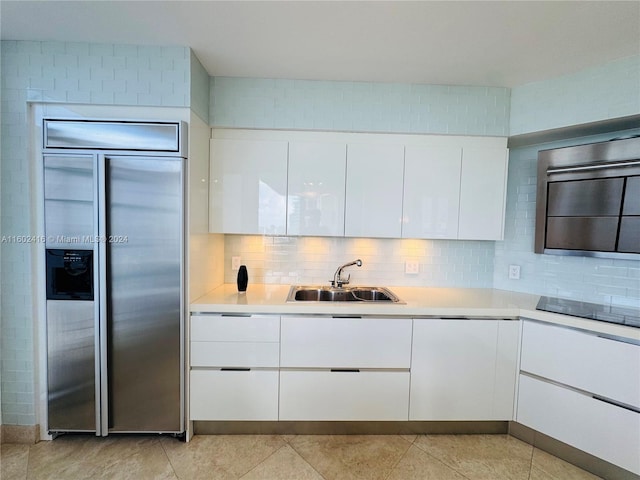 kitchen featuring paneled refrigerator, white cabinets, modern cabinets, and a sink