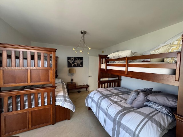 bedroom with light tile patterned floors and an inviting chandelier