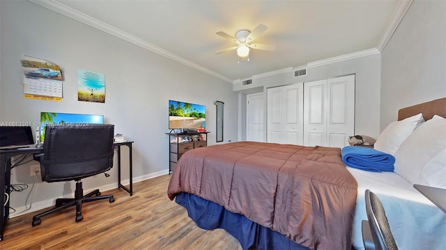 bedroom featuring hardwood / wood-style floors, ceiling fan, a closet, and crown molding