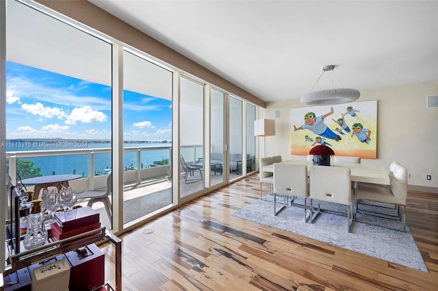 dining area with a water view and wood-type flooring