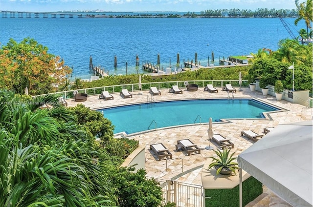 view of swimming pool with a patio area and a water view