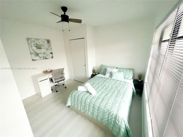 bedroom with a closet, ceiling fan, and light wood-type flooring