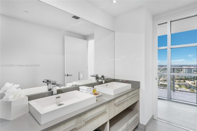 bathroom with hardwood / wood-style floors, oversized vanity, and double sink