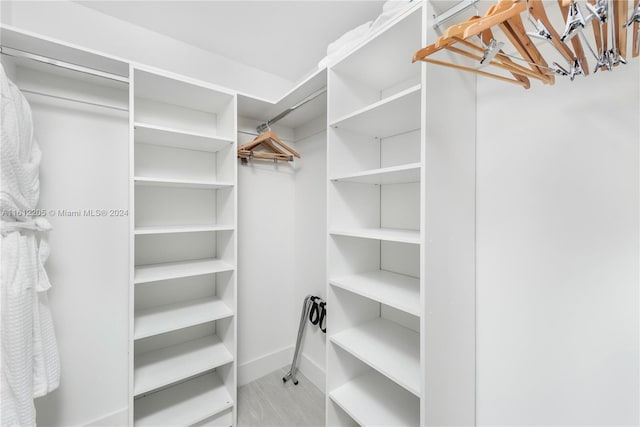 walk in closet with an inviting chandelier