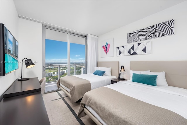 carpeted bedroom featuring floor to ceiling windows and access to exterior