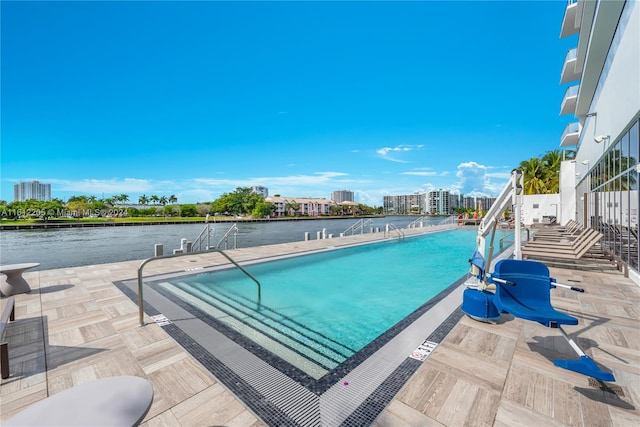 view of pool with a patio and a water view