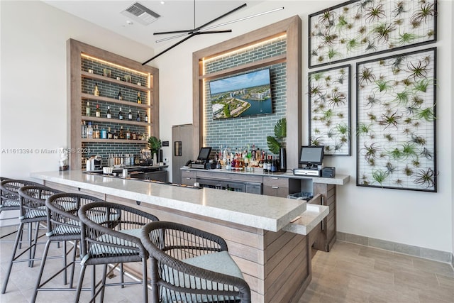 bar with ceiling fan and light tile flooring