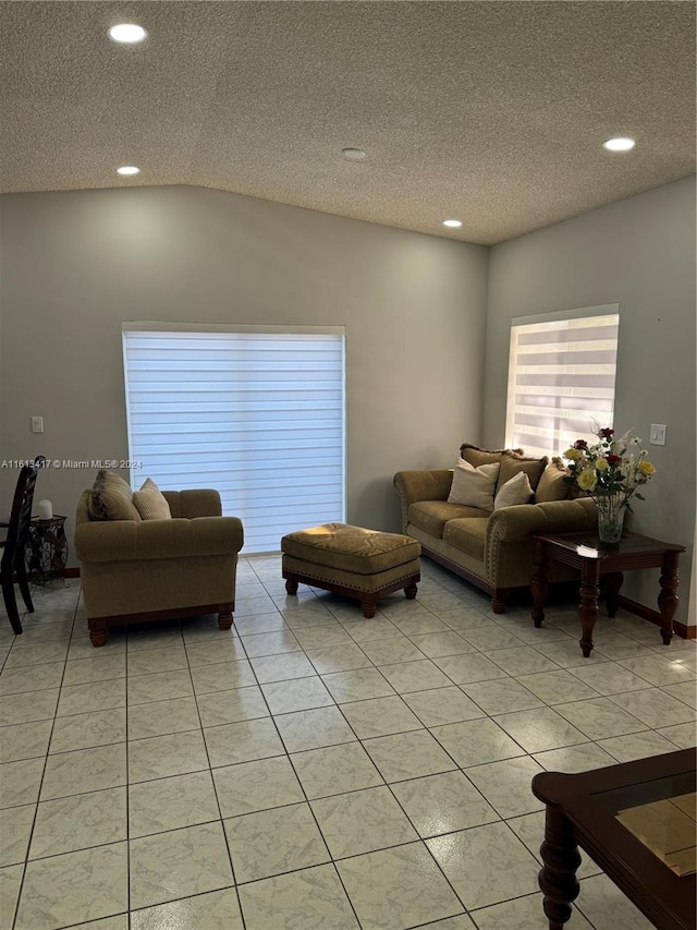 living room featuring vaulted ceiling, a textured ceiling, and light tile patterned floors