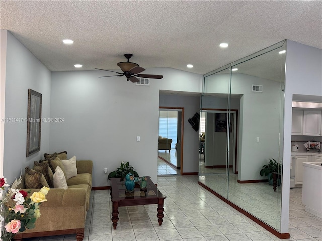 living room featuring a textured ceiling, ceiling fan, light tile patterned floors, and vaulted ceiling