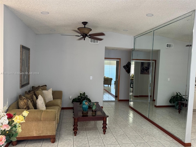 tiled living room with lofted ceiling, a textured ceiling, and ceiling fan