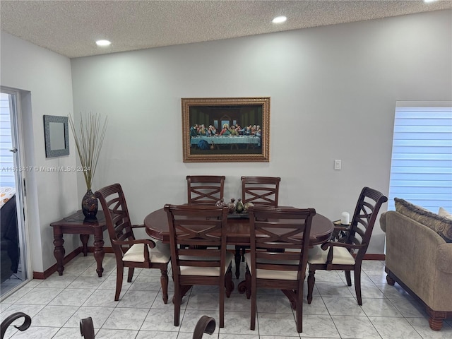 dining area with a textured ceiling and light tile patterned floors