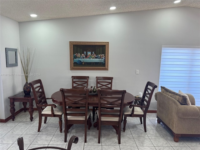 dining space featuring light tile patterned floors, a textured ceiling, and vaulted ceiling