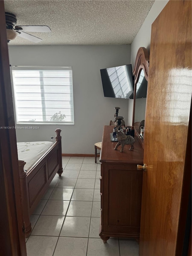 bathroom featuring ceiling fan, a textured ceiling, and tile patterned flooring