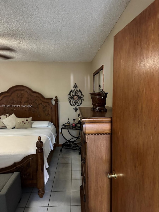 tiled bedroom featuring a textured ceiling and ceiling fan