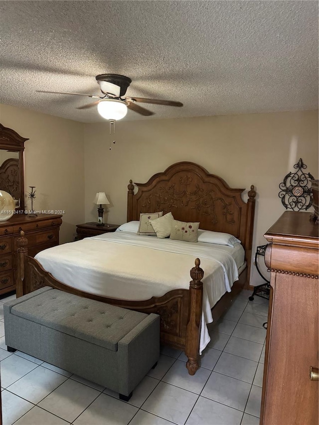 bedroom with ceiling fan, a textured ceiling, and light tile patterned floors