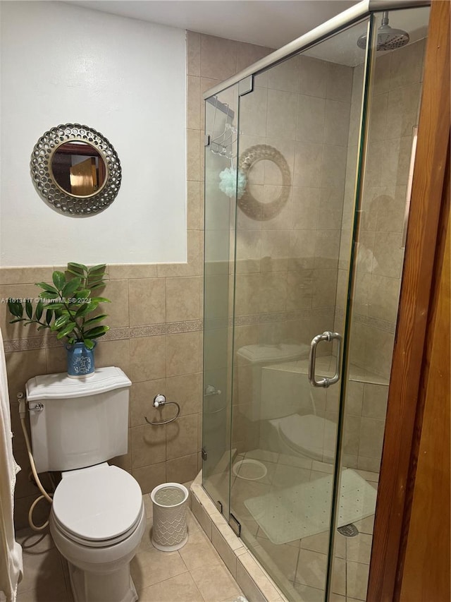 bathroom with toilet, tile patterned floors, tile walls, and an enclosed shower