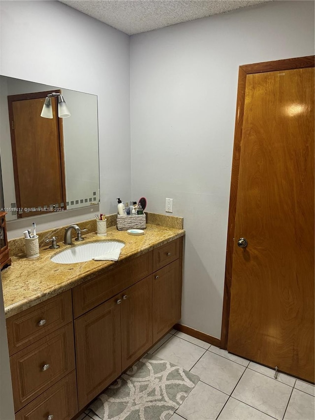 bathroom with vanity, a textured ceiling, and tile patterned floors