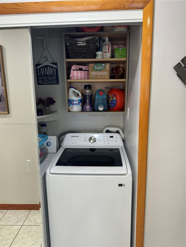 laundry area with light tile patterned floors and washer / clothes dryer