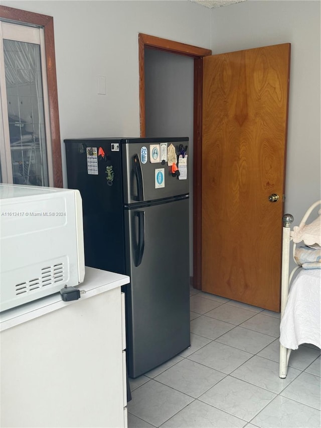 kitchen with light tile patterned floors and stainless steel refrigerator