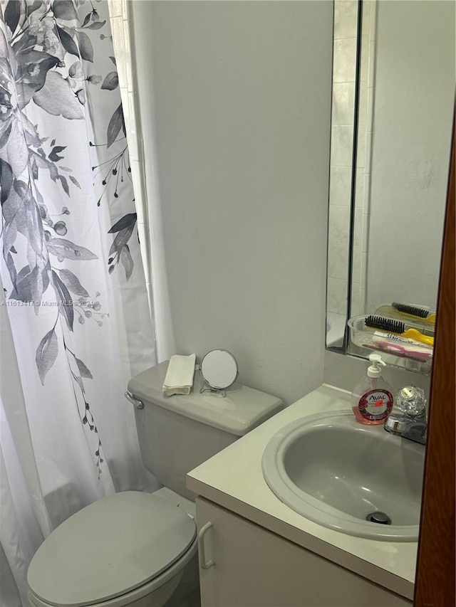 bathroom featuring vanity, a shower with shower curtain, and toilet