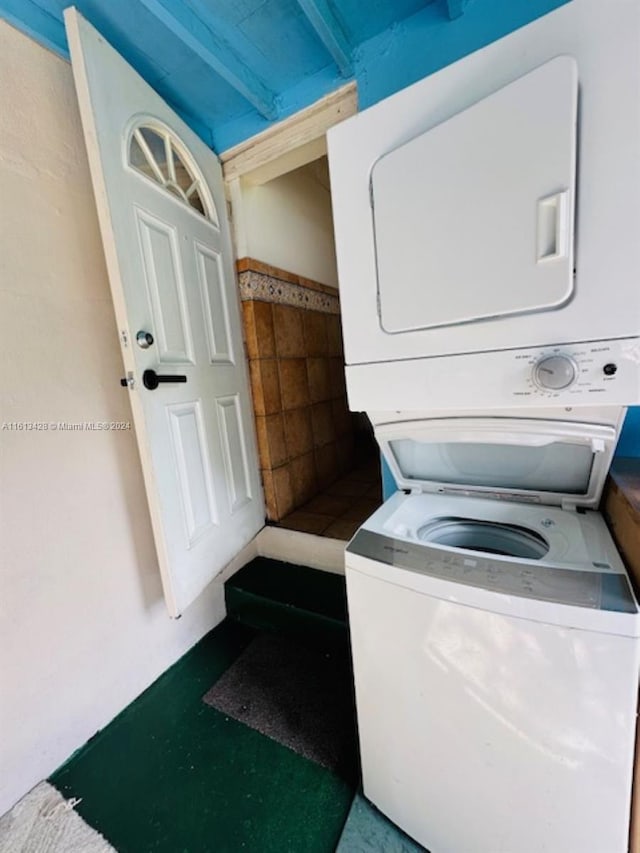 clothes washing area with stacked washer and dryer