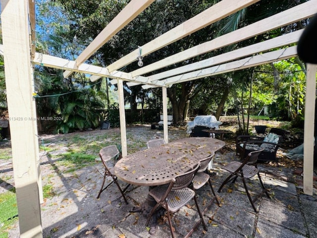 view of patio / terrace with outdoor dining area, fence, and a pergola