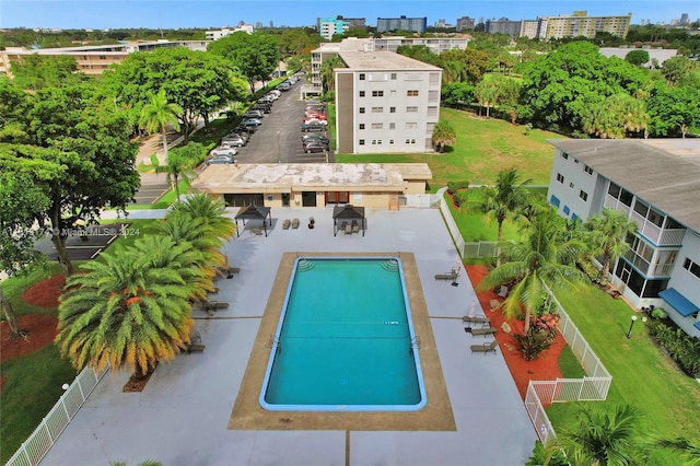 view of swimming pool featuring a view of city and fence