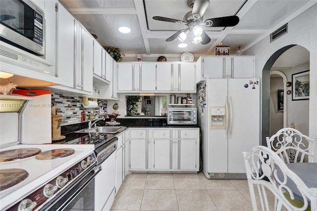 kitchen with a sink, visible vents, white appliances, and white cabinets