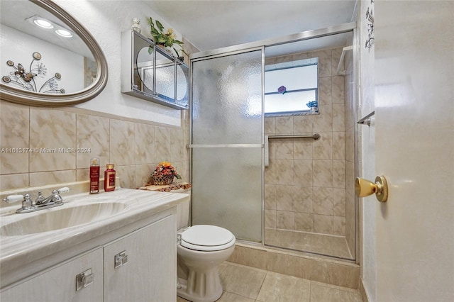 full bathroom with toilet, tile walls, a stall shower, and vanity