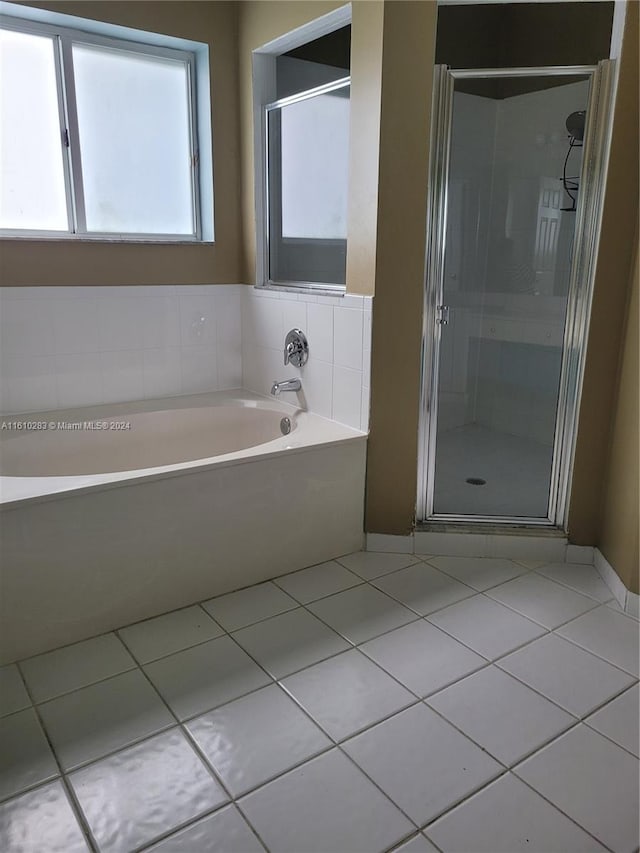 clothes washing area with light tile patterned floors and washing machine and dryer