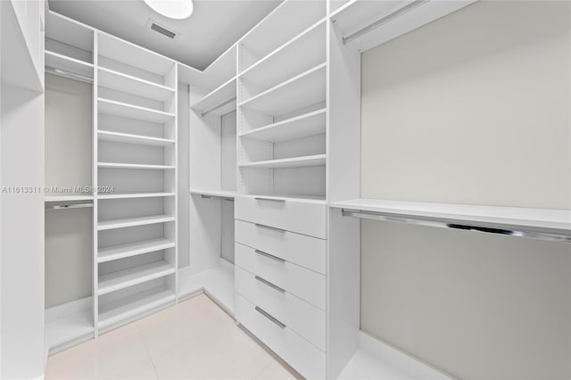 spacious closet with light tile floors