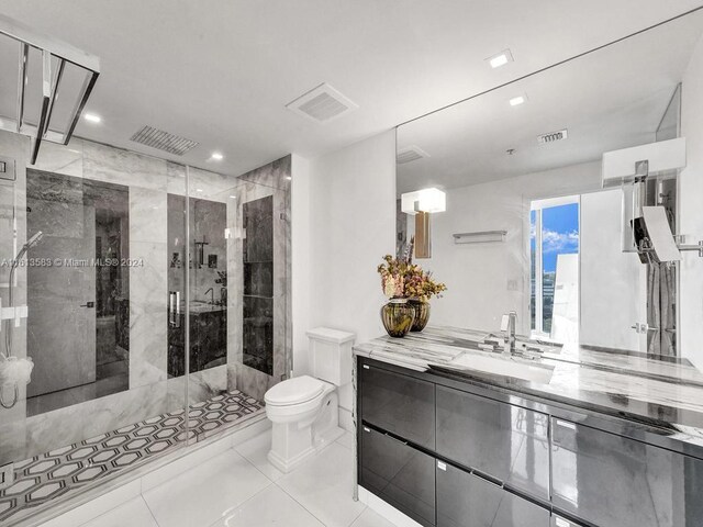 bathroom with tile patterned floors, vanity, toilet, and walk in shower