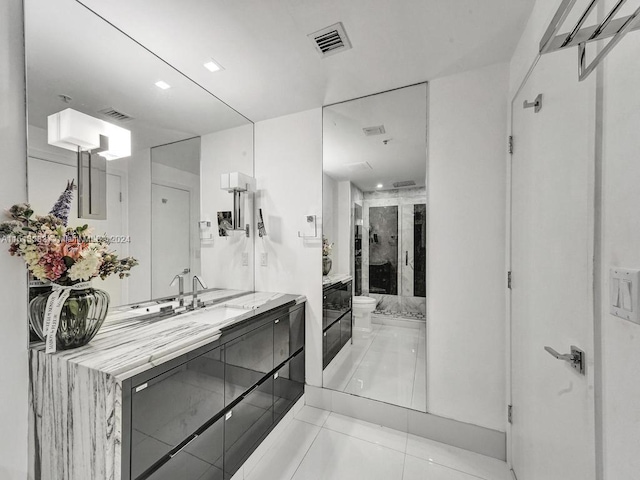 bathroom featuring tile patterned flooring, vanity, toilet, and a shower with door