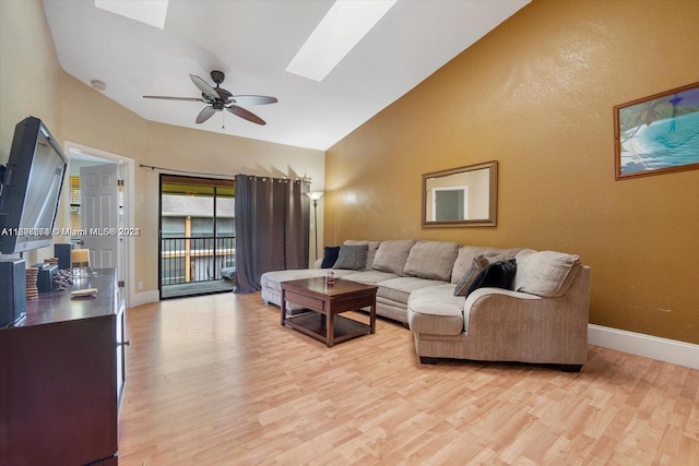 living room with vaulted ceiling with skylight, ceiling fan, and hardwood / wood-style floors