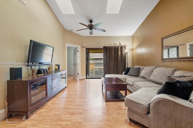 living room featuring light wood-type flooring, a skylight, and ceiling fan