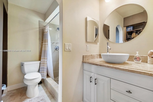 bathroom featuring a shower with shower curtain, tile flooring, vanity with extensive cabinet space, and toilet