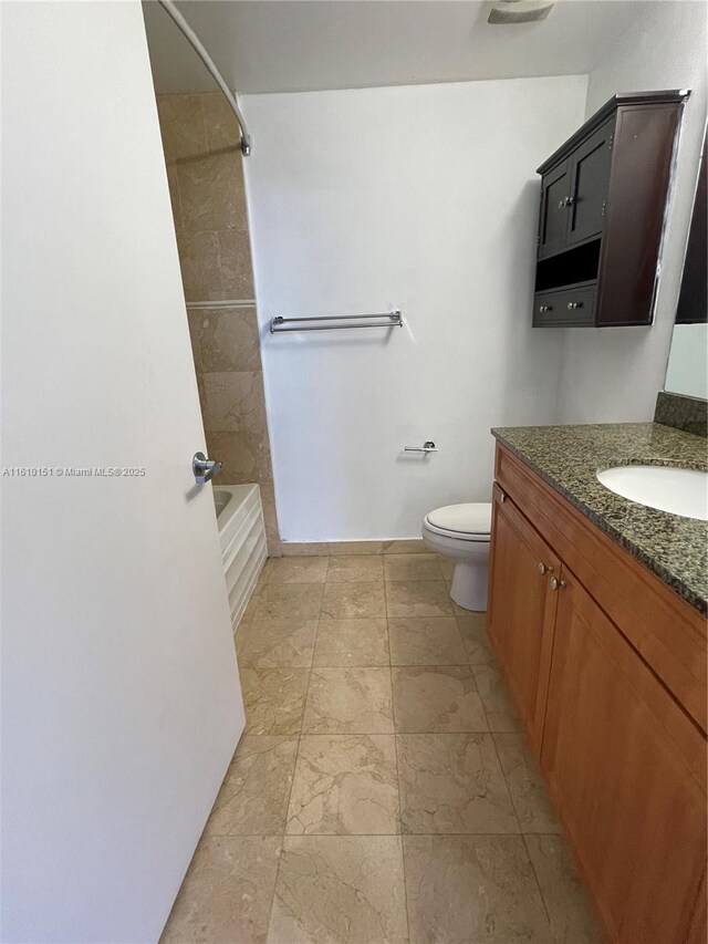 full bathroom featuring vanity, tiled shower / bath combo, and toilet