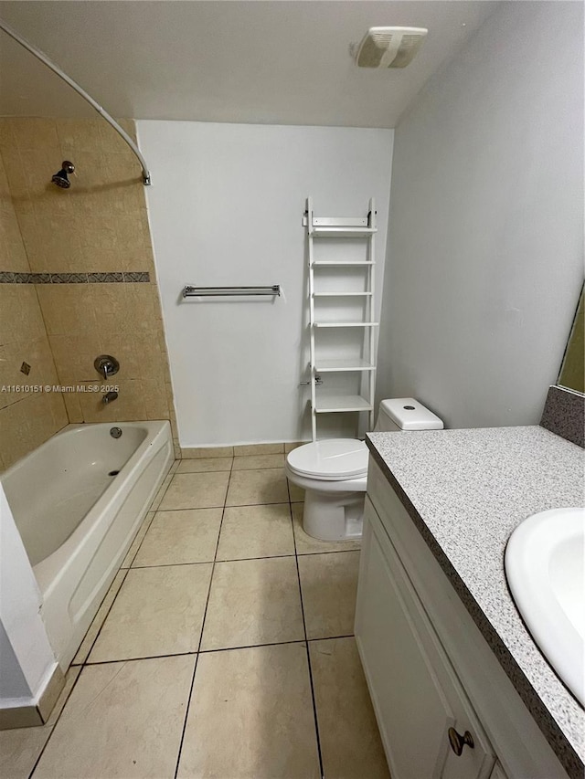 full bathroom featuring vanity, tiled shower / bath combo, tile patterned floors, and toilet