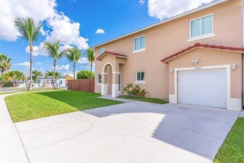 mediterranean / spanish house with a garage and a front yard